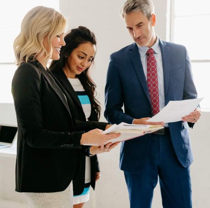 Angela Tait reviewing a hiring plan with two law firm clients